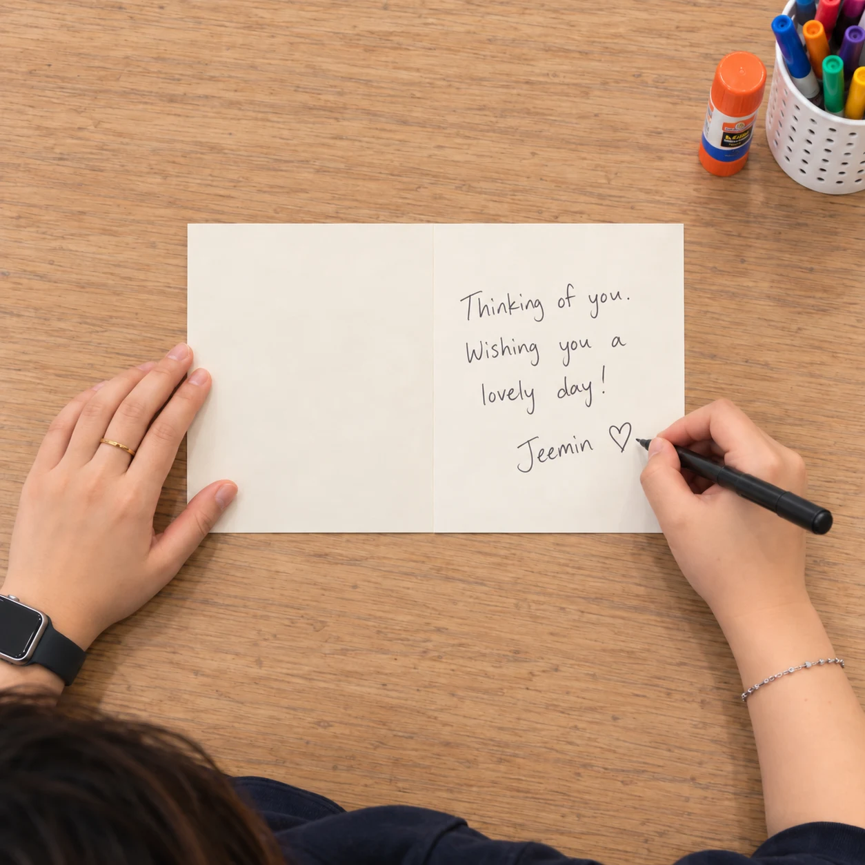 Overhead view of the open cream card with two equal panels and a handwritten message on the inside right panel